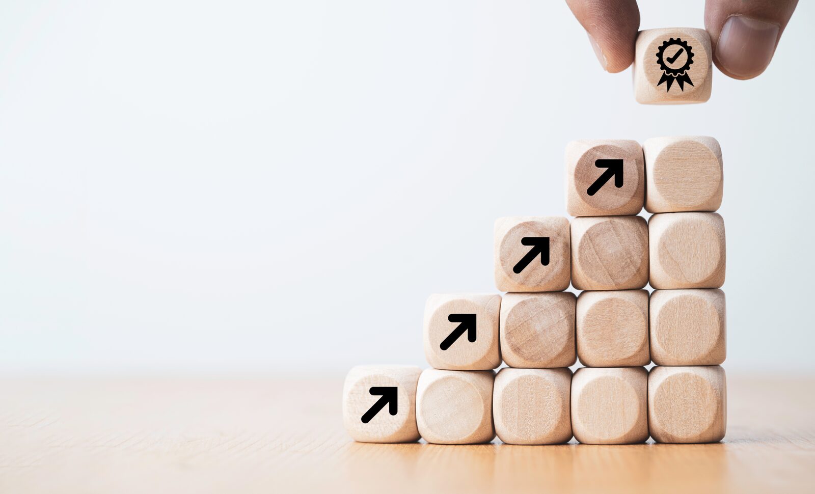 Growth Story | Career Calling International Wooden blocks arranged as a staircase with arrows symbolize growth and achievement in vocational education.
