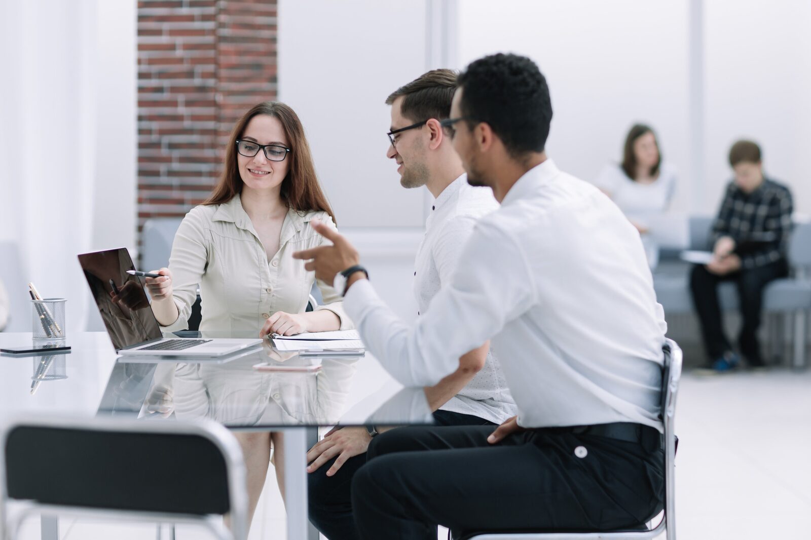 Two colleagues discuss work at a desk, demonstrating Career Calling International's commitment to education consultancy.