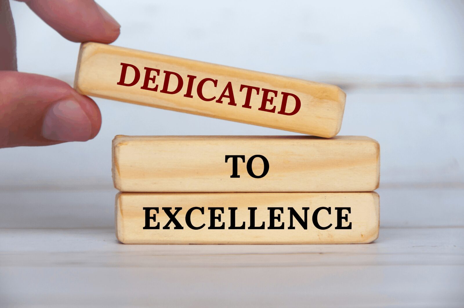 Excellence | Career Calling International Wooden blocks spell out 'Dedicated To Excellence', representing one of the core values at Career Calling International.