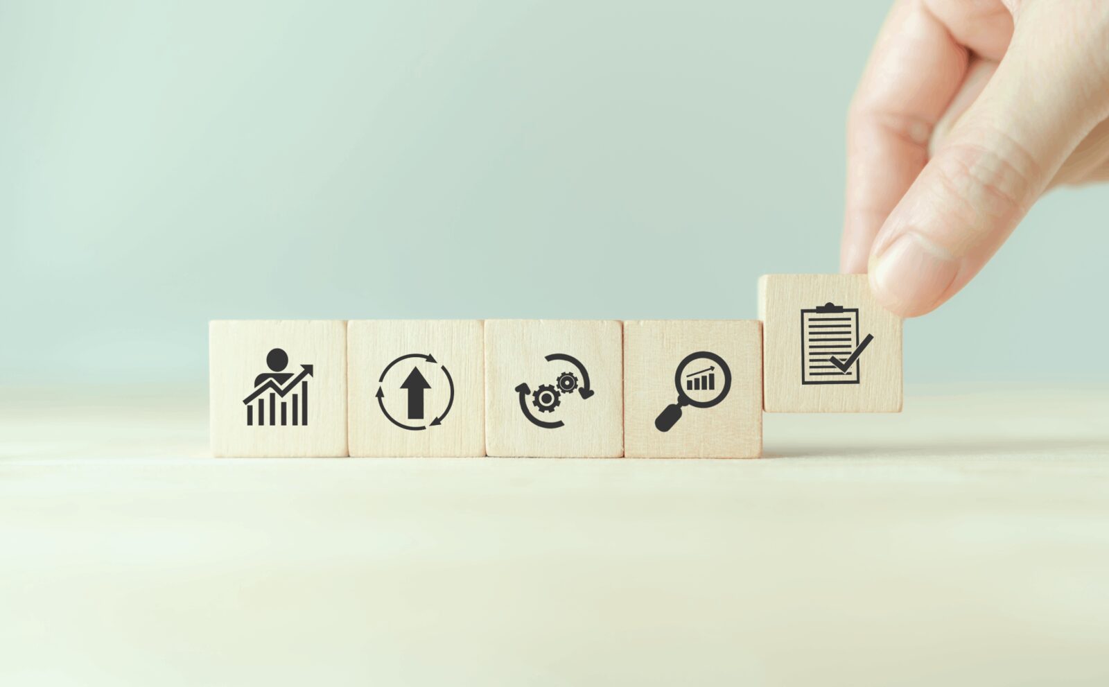 Quality Assurance Process | Career Calling International Wooden blocks with icons illustrate the quality assurance process for vocational education training resources.