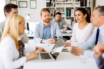 A diverse team collaborates during a business meeting, showcasing effective teamwork for vocational education training.