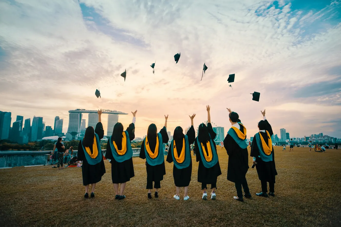 Graduation Celebration | Career Calling International Students celebrate their graduation with a cap toss against the backdrop of a city skyline and vocational education training.