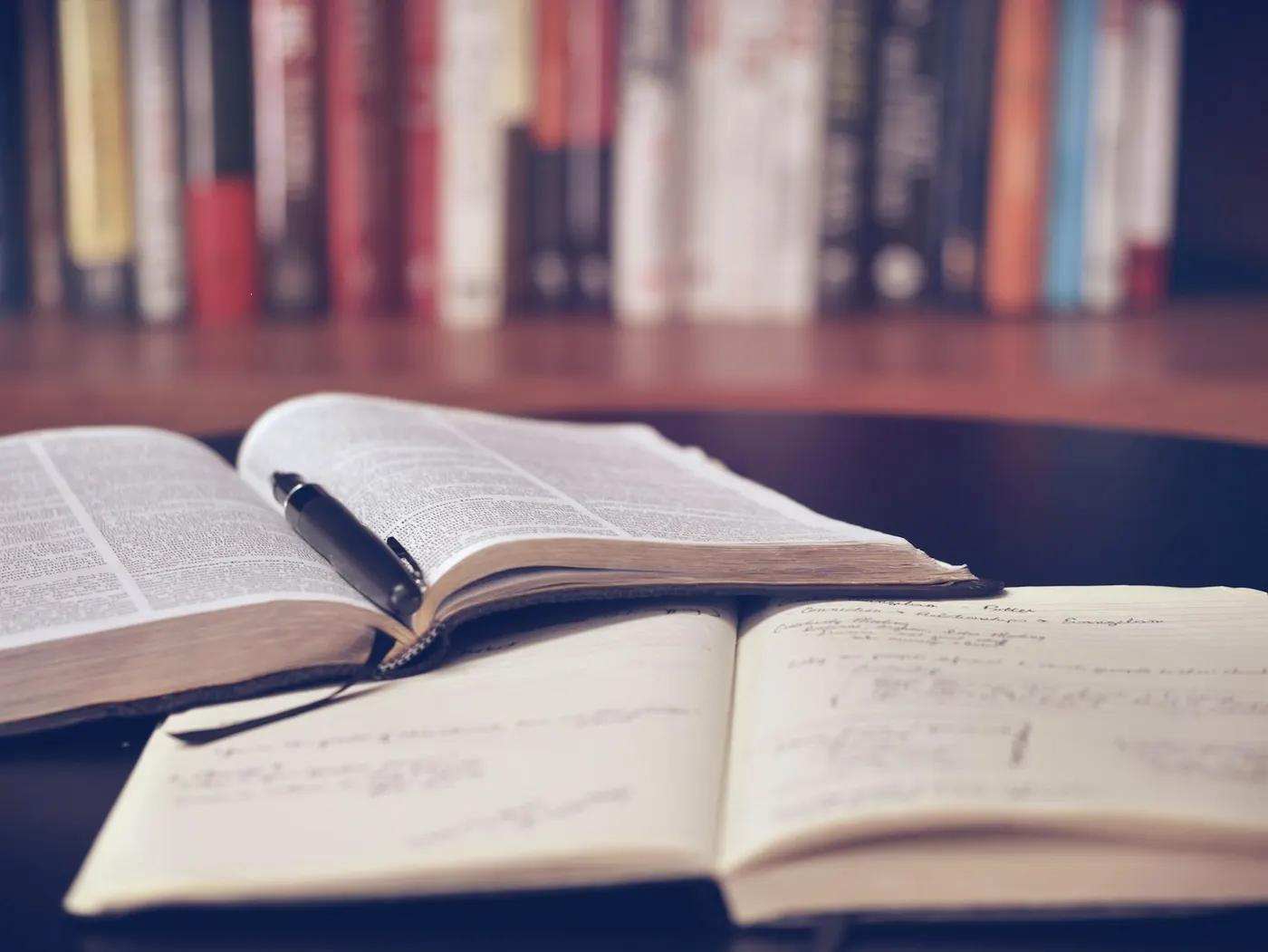 Open books and a pen rest on a table, representing vocational education training resources.