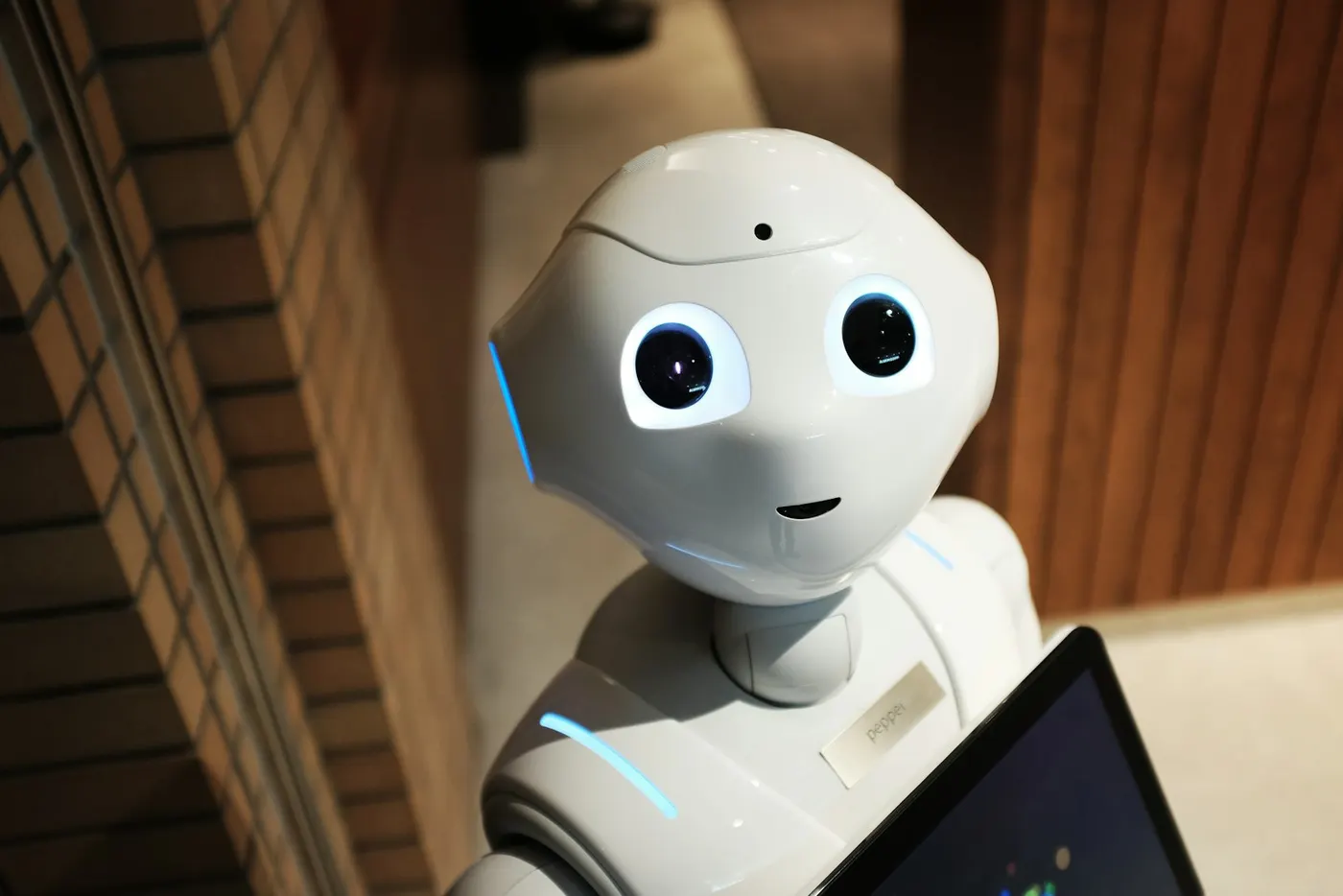 A white Pepper robot stands indoors, demonstrating technology used in vocational education and training.
