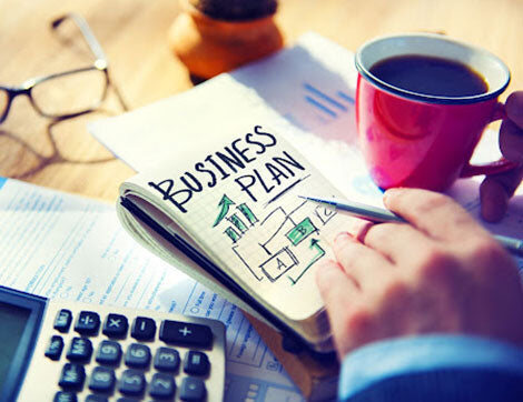 Business Planning | Career Calling International A person works on a business plan with financial documents and coffee, supporting vet compliance.
