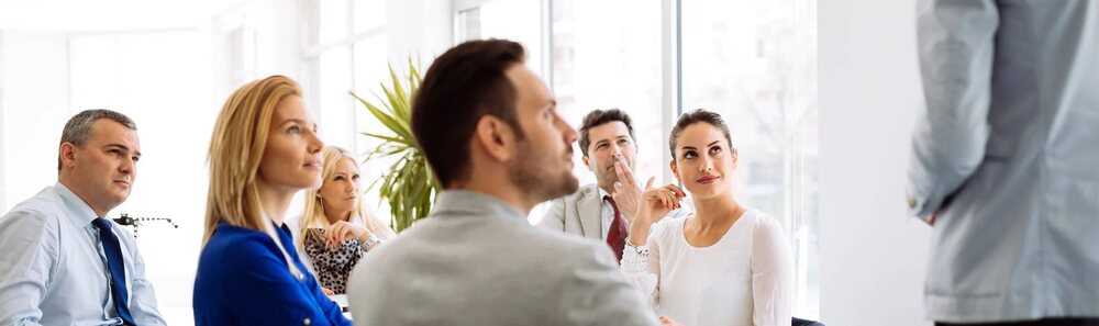 Career Calling Advice | Career Calling International Business professionals engage with a presenter during an office meeting, reflecting our education consultancy services.