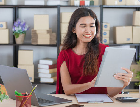 Small Business Owner | Career Calling International A woman reviews documents at a desk, showcasing Career Calling International's vet compliance services.