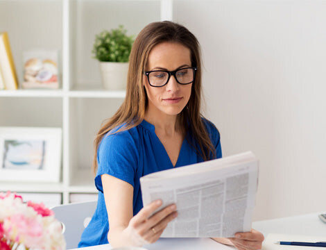 Woman Reading | Career Calling International A woman reads a newspaper while learning about vocational education and training.