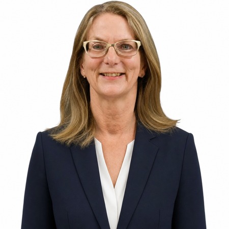 A professional woman named Anna Haranas smiles while wearing a dark suit, representing our vet compliance expertise.